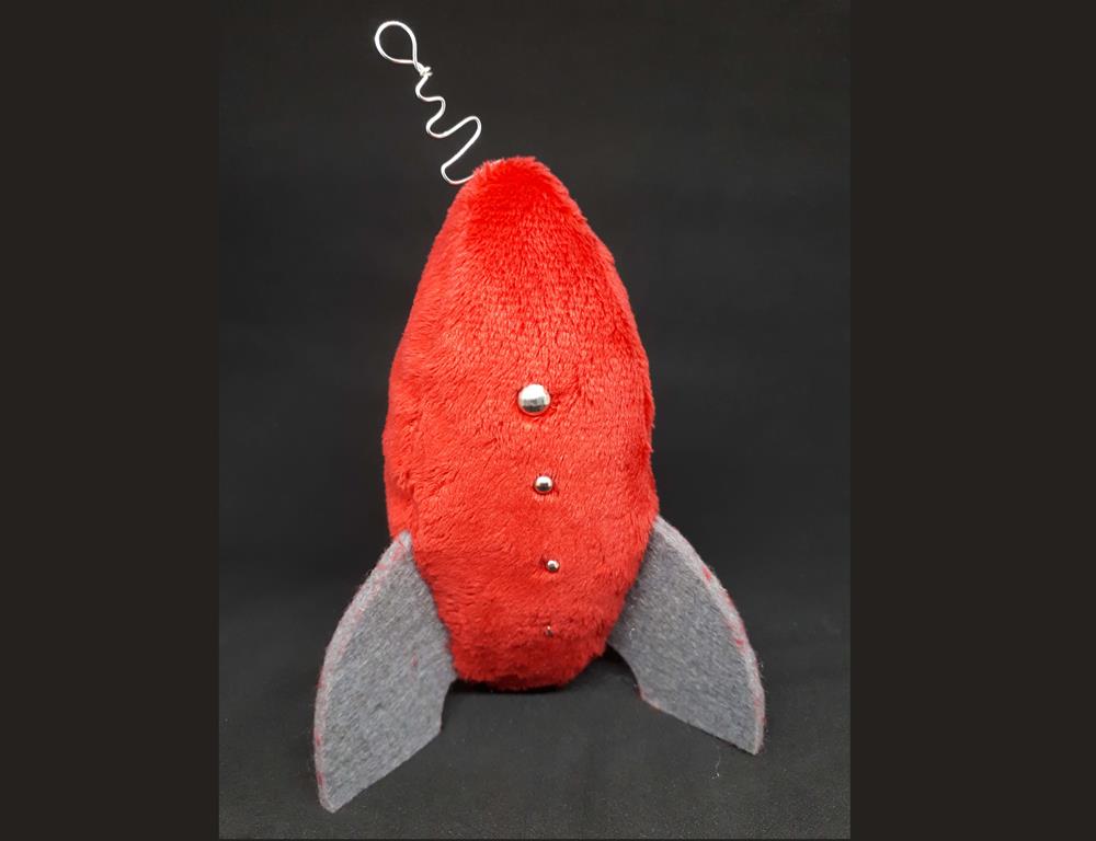 A fuzzy red rocketship with rounded grey fins and silver dots down the sides.