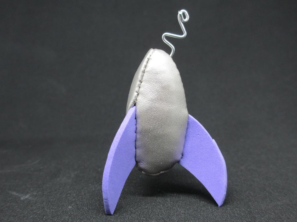Tiny silver rocketship with purple fins.