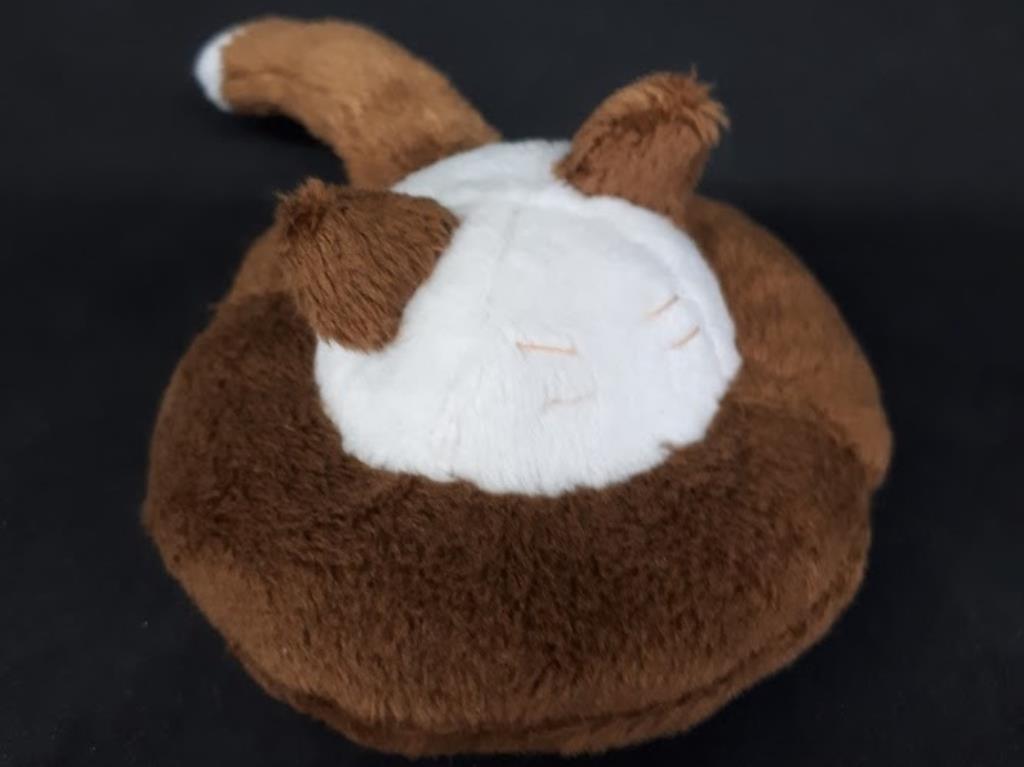 A flying saucer with cat ears, a tail, and whiskers. It is brown and white.