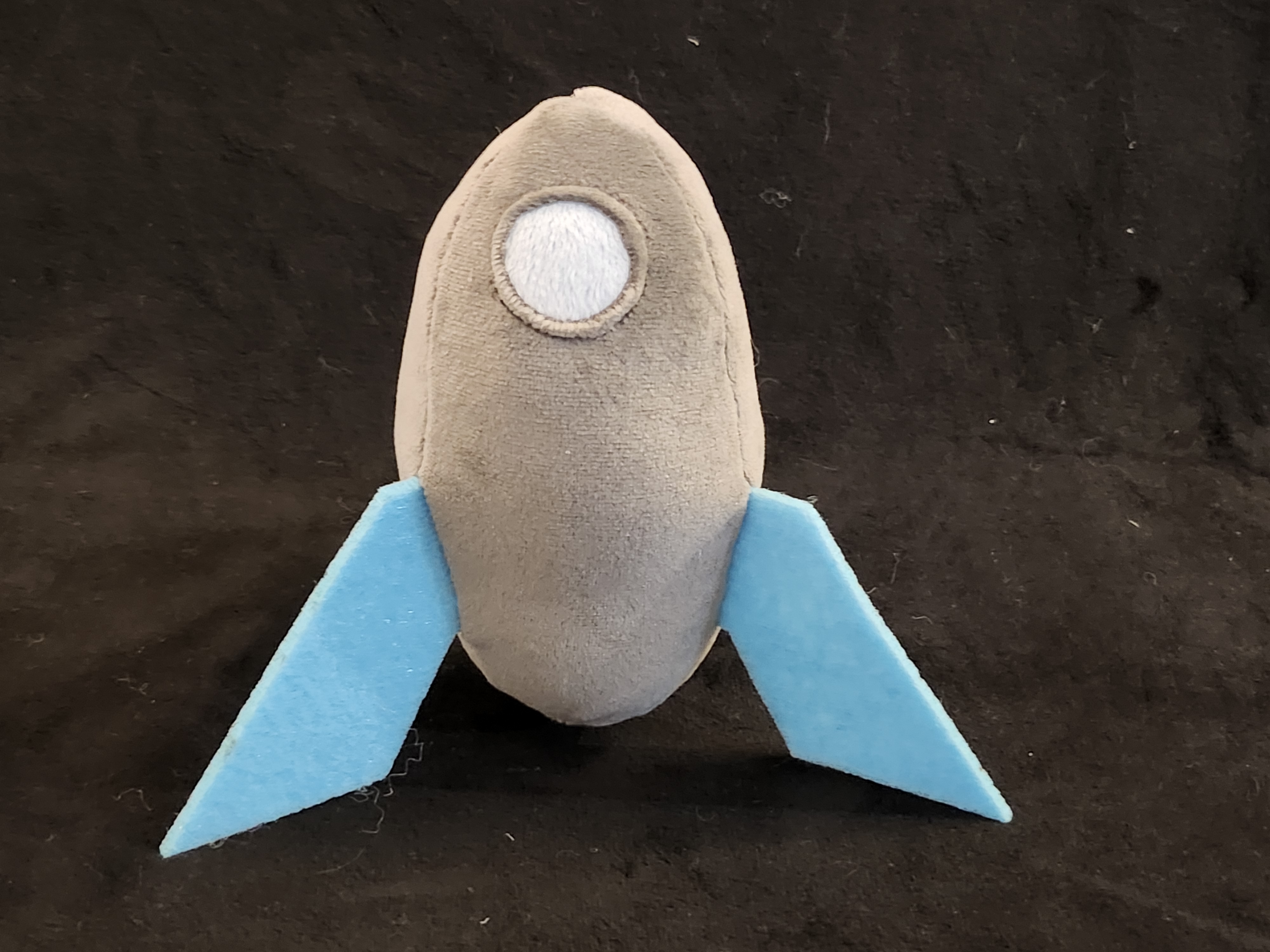 A grey rocketship with blue fins.